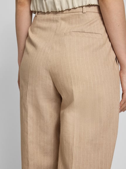 Vrouwenmodel draagt Weite Hose Baumwoll-Mix met Leinen-Anteil Model 'HENESA' van HUGO in beige met krijtstreepmotief, katoenmix, achterzak, riemlussen, all-over motief, detailopname achterkant.