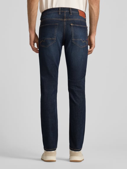 Männermodel trägt Jeans mit Eingrifftaschen Modell 'ARNE PIPE' von MAC, Baumwoll-Mix mit Stretch-Anteil, Slim-Fit, Ganzkörperansicht Rückansicht.