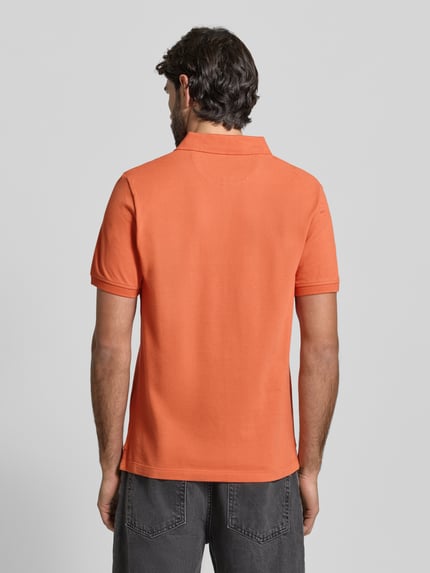 Männermodel trägt Regular Fit Poloshirt aus reiner Baumwolle von s.Oliver RED LABEL in Orange, unifarben, Piqué, Ganzkörperansicht Rückansicht.