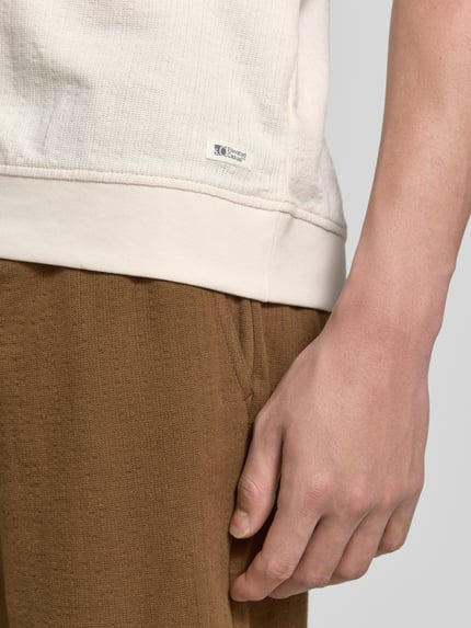 Mannenmodel draagt Regular Fit poloshirt uit puur katoen van s.Oliver RED LABEL, look: effen, labelpatch, jersey, detailopname zijkant bovenbeen.
