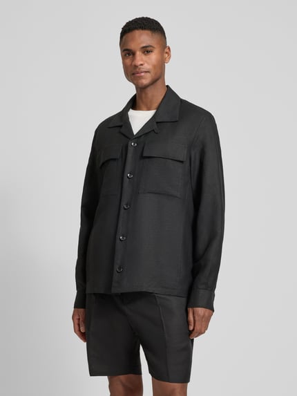Męski model nosi Regular Fit Hemdjacke aus Leinen-Viskose-Mix Modell 'ANTIGUA' od Antony Morato, mieszanka lnu i wiskozy, krój regular fit, kołnierz z połami, kieszenie na piersi, długość tyłu w rozmiarze 50: 72 cm, widok całej sylwetki z przodu.