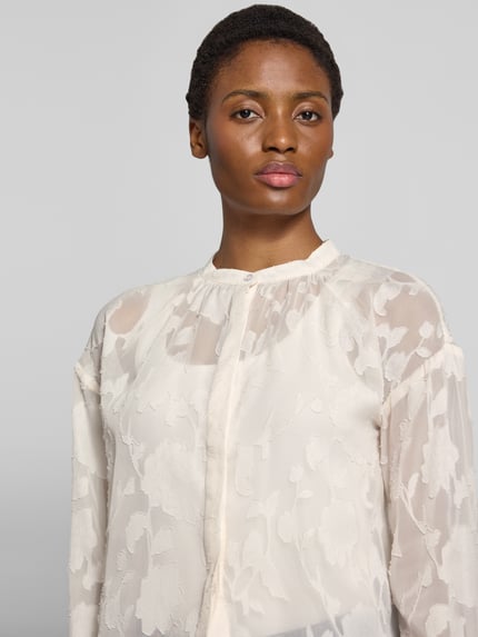 Vrouwenmodel draagt Regular fit blouse met bloemenmotief Model 'Malina' van GUIDO MARIA KRETSCHMER WOMAN, ronde hals, blouse met lange mouwen, knoopsluiting, ruglengte maat 36: 46 cm, mouwlengte maat 36: 57 cm, lichte kleuren, transparante textuur, detailopname bovenlichaam.