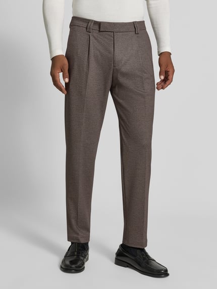 Männermodel trägt Regular Fit Anzug mit Viskose-Anteil Modell 'Ponza' von CINQUE in Braun mit Bügelfalte, Nahaufnahme Unterkörper. Material wirkt elastisch, feine Struktur, moderner Look.