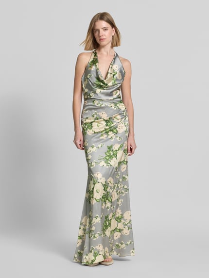 Frauenmodel trägt Abendkleid mit floralem Allover-Print von Mascara aus Satin, Taillierte Passform, Neckholder, Rückenausschnitt, Ganzkörperansicht von vorne.