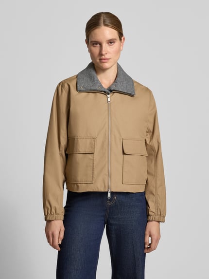 Vrouwenmodel draagt Regular fit dames jack van Samsøe Samsøe, Materiaalmix met katoen, model 'Bianco', platte kraag, opgestikte zakken, ruglengte maat S 55 cm, schouderbreedte 46 cm, borstwijdte 60 cm, mouwlengte 63 cm, beige, gladde stof, donkerblauwe jeans, Ganzkörperansicht von vorne.