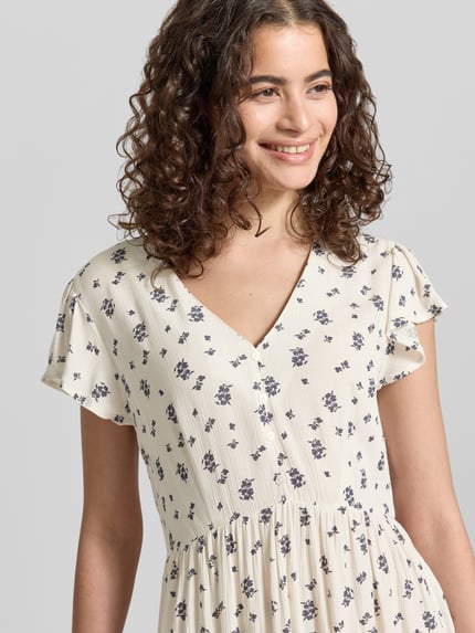 Frauenmodel trägt tailliertes Damen Freizeitkleid von Only, Modell 'CLAUDETTE', Optik: Allover-Muster, V-Ausschnitt, reine Viskose, Nahaufnahme Oberkörper.