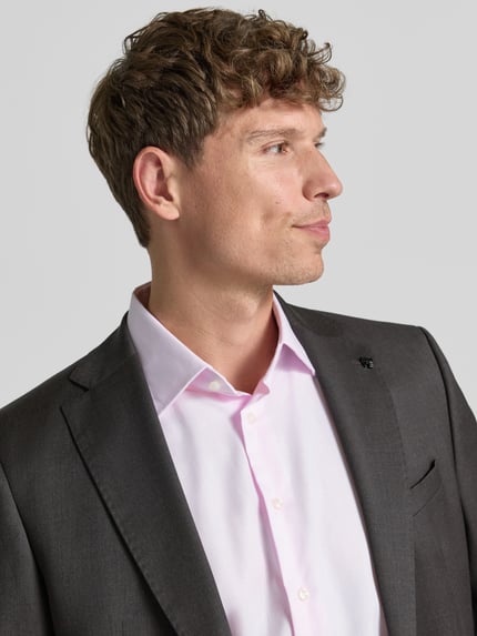 Männermodel trägt Regular Fit Business-Hemd mit Kentkragen von Christian Berg Men, hellrosa, glatte Baumwolle, Nahaufnahme Oberkörper. Rückenlänge 78 cm, Schulterbreite 45 cm, Ärmellänge 65 cm, langärmelig, durchgängige Knopfleiste.