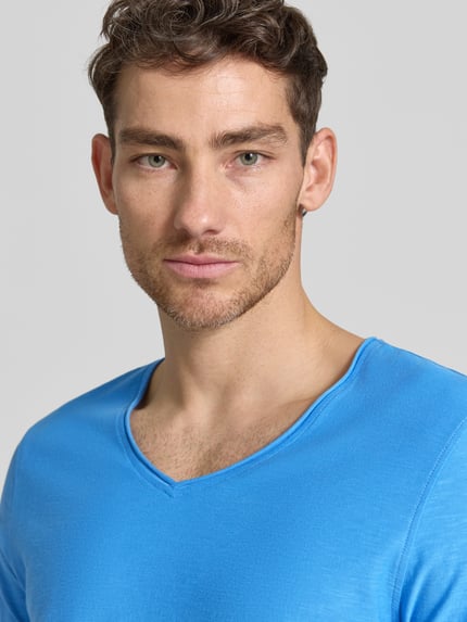 Männermodel trägt Regular Fit T-Shirt mit V-Ausschnitt von MCNEAL aus reiner Baumwolle in Blau, Nahaufnahme Oberkörper.