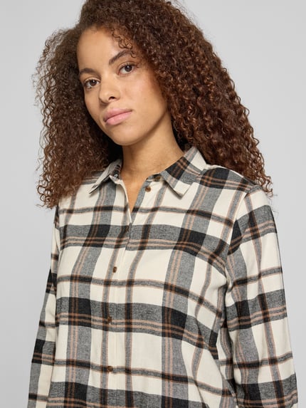 Frauenmodel trägt Regular Fit Hemdbluse mit abgerundetem Saum von ONLY in Creme mit Karomuster, weiche Textur, Nahaufnahme Oberkörper, Damen Hemdbluse von ONLY.