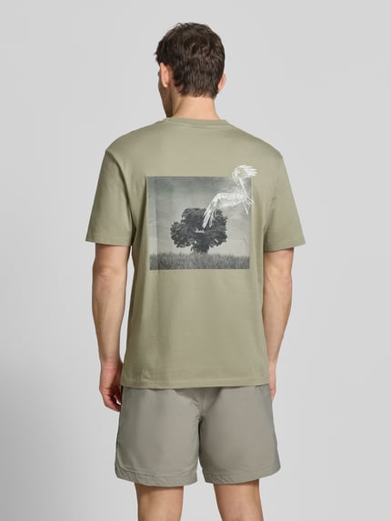 Mężczyzna nosi Relaxed Fit T-Shirt mit Rückenprint od HUGO, wielokolorowa bawełna, nadruk z logo, okrągły dekolt, krótki rękaw, widok z tyłu całej sylwetki.