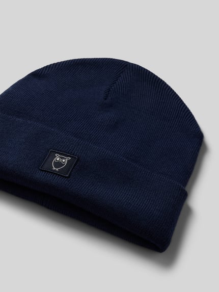 Produktfoto, dunkelblaue Mütze aus reiner Wolle Modell 'Merino' von Knowledge Cotton Apparel, Strick-Optik, Logo-Patch, glatte Struktur