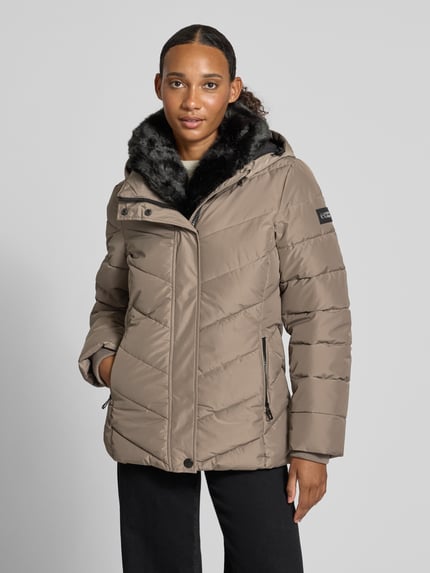 Frauenmodel trägt Regular Fit Jacke in Stepp-Optik von NAUTGÅRD, beige Farbe, Kunstfellbesatz, Taschen, Ganzkörperansicht von vorne. Kontext: Damen Jacke mit Stepp-Optik, Regular Fit, Kunstfellbesatz, Eingrifftaschen, Rückenlänge bei Größe S 68 cm, Schulterbreite 43 cm, Brustweite 47 cm, Ärmellänge 66 cm.