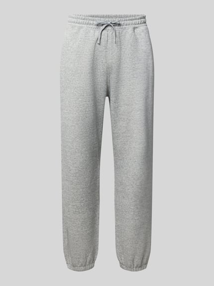 Produktfoto, Sweatpants mit Label-Detail von Champion aus grauer Baumwollmischung, gerader Schnitt, Elastikbund mit Tunnelzug, seitliche Eingrifftaschen, 75 cm Innenbeinlänge bei Größe M, strukturierte Textur.