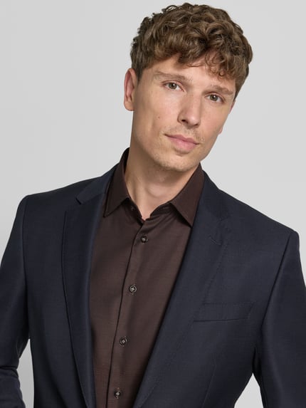 Männermodel trägt Slim Fit Business-Hemd mit Kentkragen von Christian Berg Men aus Reine Baumwolle, Knopfleiste, Nahaufnahme Oberkörper.