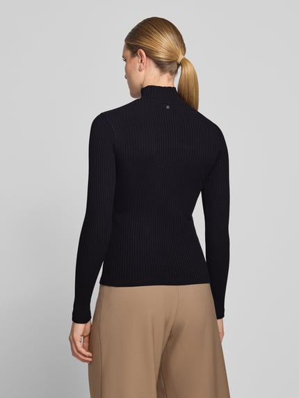 Frauenmodel trägt czarną prążkowaną bluzkę z długim rękawem Slim Fit Langarmshirt aus Baumwoll-Mix Modell 'Driza_4' von HUGO, Damski t-shirt od HUGO, Ganzkörperansicht Rückansicht.