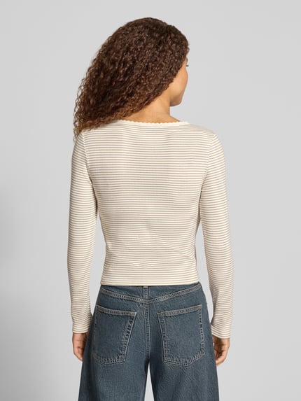 Frauenmodel trägt Slim Fit Langarmshirt aus Baumwoll-Mix von Levi's® 300 in Beige mit feinen Streifen und glatter Textur, Ganzkörperansicht Rückansicht.