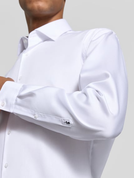 Męski model nosi Slim Fit Businesshemd aus reiner Baumwolle Modell 'New Kent' von Seidensticker, biała gładka tkanina, zbliżenie na górną część ciała, koszula biznesowa męska