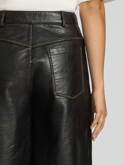 Frauenmodel trägt Shorts in Leder-Optik Modell 'SILJE' von Topshop, schwarze strukturierte Oberfläche, Detailaufnahme Rückansicht, Material-Mix mit Viskose-Anteil, Regular Fit