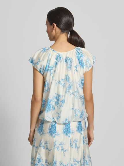 Frauenmodel trägt Regular Fit Bluse aus Lyocell-Mix Modell 'Evangelia' von MSCH Copenhagen mit blauem Floraler Allover-Print, Falten-Optik, kurzärmelig, Rückenlänge bei Größe S: 50 cm. Ganzkörperansicht Rückansicht.