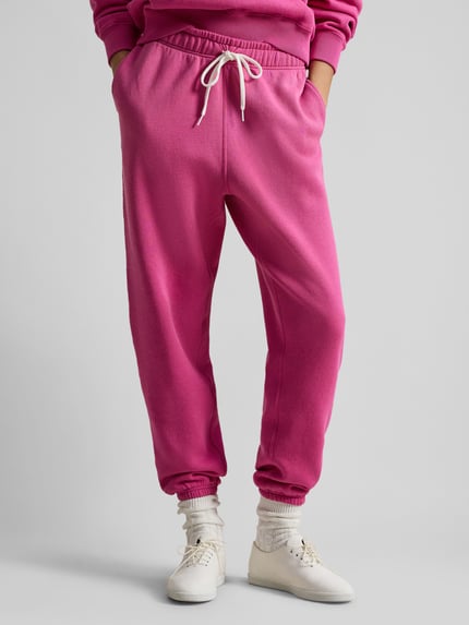 Frauenmodel trägt Comfort Fit Sweatpants aus reiner Baumwolle von Polo Ralph Lauren in Pink mit Tunnelzug, elastischem Bund und Logo-Stitching, seitliche Eingrifftaschen, Sweat-Material, unifarben, Ganzkörperansicht von vorne.