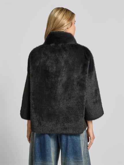 Männermodel trägt Wendejacke aus Kunstfell von Juvia in Schwarz, funkcja dwustronna, stójka, wpuszczane kieszenie, prosty krój, Długość tyłu w rozmiarze S: 63 cm, Szerokość w rozmiarze S: 54 cm, Długość rękawów w rozmiarze S: 47 cm, Ganzkörperansicht Rückansicht.