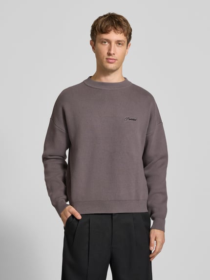 Männermodel trägt Strickpullover mit Label-Stitching Modell 'BACK IN THE DAYS' von PROHIBITED in Grau, Regular Fit, Rundhalsausschnitt, Ganzkörperansicht von vorne. Rückenlänge 62 cm, Ärmellänge 57 cm.
