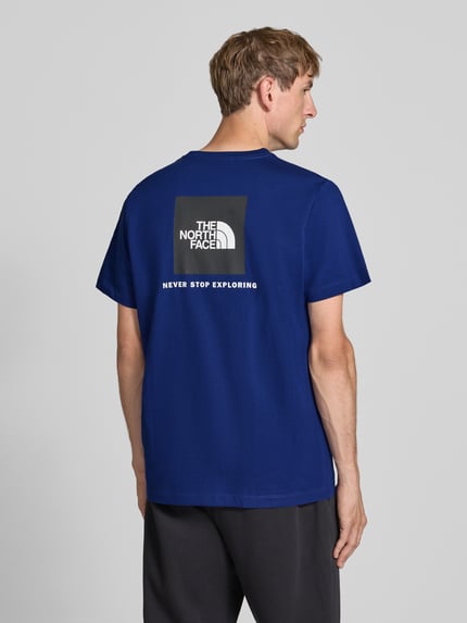 Männermodel trägt T-Shirt mit Label-Print Modell 'Evolution' von The North Face, blau, Baumwoll-Mix, Regular Fit, Ganzkörperansicht Rückansicht