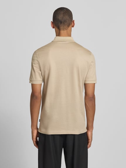 Männermodel trägt Regular Fit Poloshirt aus Baumwoll-Lyocell-Mix Modell 'H-PARAS 70' von BOSS in Beige, unifarben, Rückansicht.