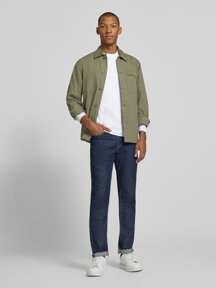 Männermodel trägt Longsleeve aus reiner Baumwolle von Christian Berg Men in Weiß, kombiniert mit Jeans, lockere Passform, Ganzkörperansicht von vorne.