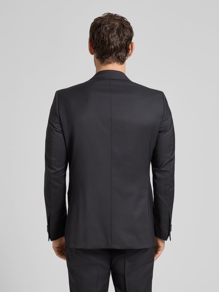Männermodel trägt Regular Fit 2-Knopf-Sakko Modell 'Colvin' von CG - Club of Gents aus Reine Schurwolle, Rückenansicht Ganzkörperansicht.