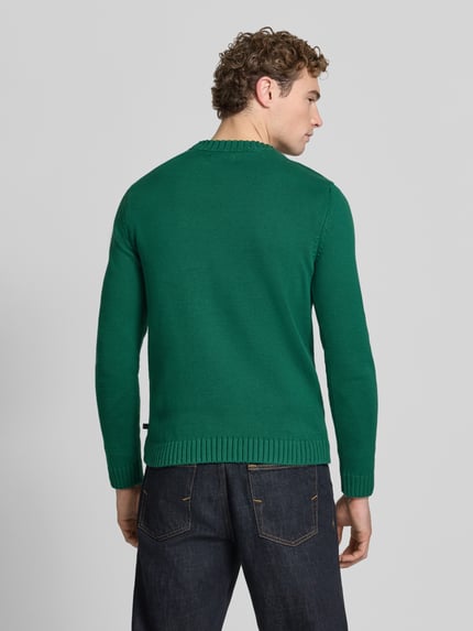 Männermodel trägt Pullover mit markanten Teilungsnähten von S.OLIVER CASUAL, grün, Feinstrick, Rundhals, gerippte Abschlüsse, Rückansicht Ganzkörperansicht.