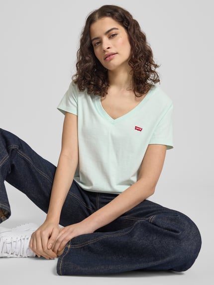 Kobiece model prezentuje Regular Fit T-Shirt aus reiner Baumwolle Modell 'LSE_PERFECT TEE' von Levi's®, kolor jednolity, V-neck, krótki rękaw, bawełna, haftowane logo, krój regular fit, zdjęcie całej sylwetki z przodu.