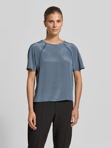 Frauenmodel trägt Regular Fit Bluse mit Zierbesatz von Luisa Cerano aus Baumwoll-Modal-Mix in Blau mit Rundhalsausschnitt, kurzärmelig, Ganzkörperansicht von vorne.