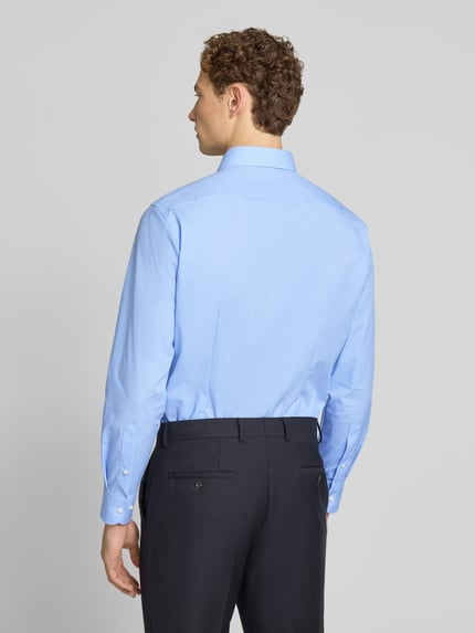 Männermodel trägt Modern Fit Business-Hemd mit Kentkragen von OLYMP in Hellblau und dunkler Hose, Ganzkörperansicht Rückansicht.