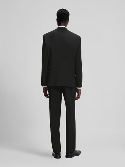 Męski model nosi Slim Fit Anzugsakko aus Woll-Mix Modell 'ARTI' od HUGO o melanżowym wyglądzie, ciemna kolorystyka, pełny tył, Ganzkörperansicht Rückansicht