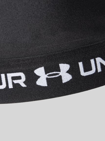 Produktfoto, schwarzer Sport-BH mit Logo-Print von Under Armour, glatte Oberfläche, weißer Schriftzug und Under Armour Logo, Detailaufnahme.
