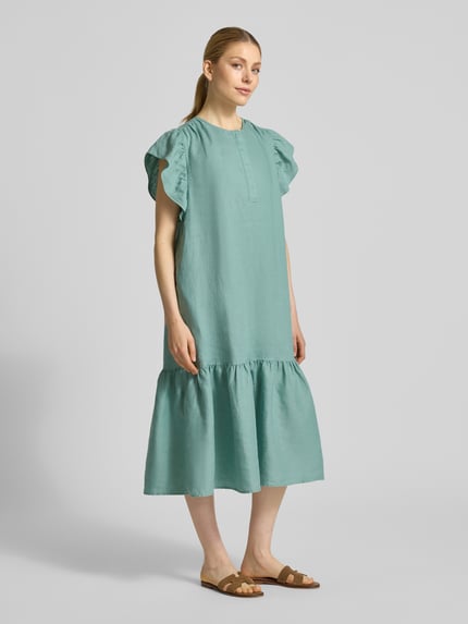 Frauenmodel trägt Leinenkleid mit Rüschen und Rundhalsausschnitt von Christian Berg Woman in Mintgrün, A-Linie, Midikleid, Ganzkörperansicht von vorne.