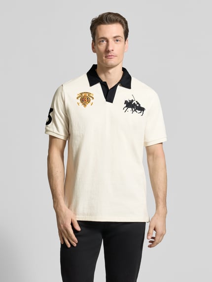 Männermodel trägt Regular Fit Poloshirt aus reiner Baumwolle von Polo Ralph Lauren, unifarben mit Logo-Stitching, Ganzkörperansicht von vorne.