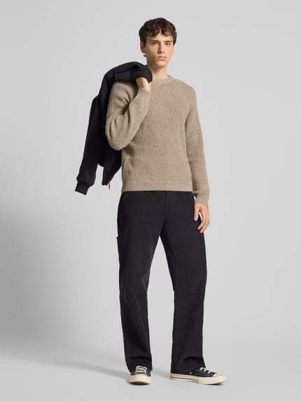 Männermodel trägt Regular Fit Strickpullover aus Baumwoll-Mix mit Woll-Anteil Modell 'LITUS' von Only & Sons, Melange-Optik, Grobstrick, Rundhals, Raglanärmel, farblich kontrastierende Hose, Ganzkörperansicht von vorne.