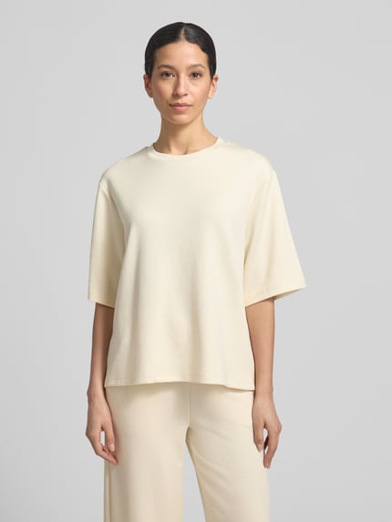 Frauenmodel trägt T-Shirt mit Rundhalsausschnitt von Soyaconcept in Beige, Relaxed Fit, glatte Textur, Material-Mix, Ganzkörperansicht von vorne.