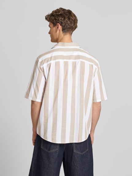 Männermodel trägt Relaxed Fit Freizeithemd aus reiner Baumwolle Modell 'TES' von Only & Sons, Optik:Allover-Muster, gestreift, Ganzkörperansicht Rückansicht.