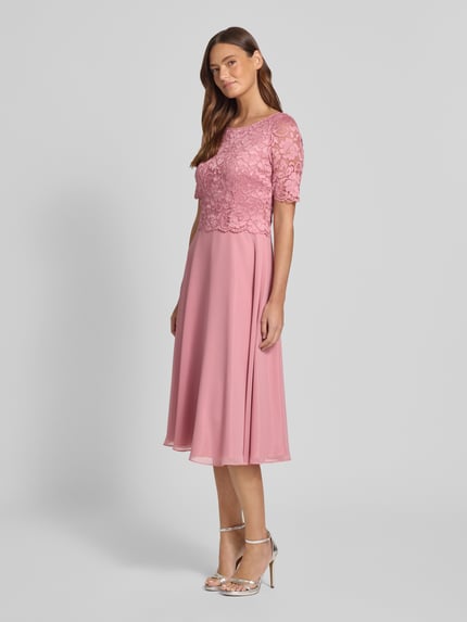 Vrouwenmodel draagt Knielanges Cocktailkleid met Spitze und Rundhalsausschnitt van Vera Mont, chiffon, a-lijn, knielengte, kant, ronde hals, ruglengte bij maat 36: 105 cm, borstwijdte bij maat 36: 40 cm, mouwlengte bij maat 36: 28 cm, zijaanzicht van voren