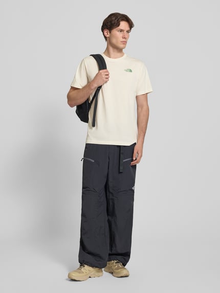 Männermodel trägt T-Shirt mit Logo und Rundhalsausschnitt von The North Face, Herren T-Shirt, Baumwoll-Mix, Regular-Fit, helle Farbe, Rückenlänge bei Größe M 72 cm, Ganzkörperansicht von vorne.