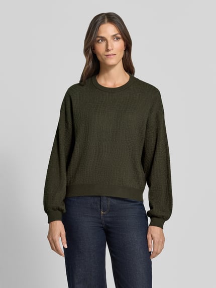 Frauenmodel trägt Regular Fit Pullover aus Viskose-Mix Modell 'NANCY' von VERO MODA in Dunkelgrün, strukturierte Oberfläche, Ganzkörperansicht von vorne. Damen Pullover.
