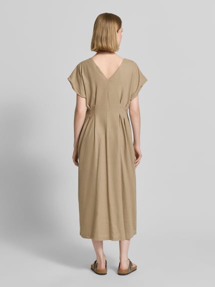 Frauenmodel trägt Midikleid aus Leinen-Viskose-Mix mit V-Ausschnitt von ICHI, Taillierter Schnitt, Modell LINNO, Allover-Look, Knopfleiste, Rückenlänge 105 cm, Brustweite 40 cm, Ärmellänge 11 cm, Ganzkörperansicht Rückansicht.