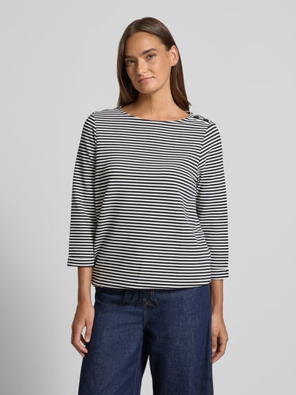 Frauenmodel trägt Relaxed Fit 3/4-Shirt aus Baumwoll-Mix von Tom Tailor mit Allover-Streifen, Zierknöpfen, U-Boot-Ausschnitt, Ganzkörperansicht von vorne.