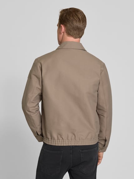 Männermodel trägt Regular Fit Blouson mit Label-Patch von Marc O'Polo × DFB Travel Collection, Optik: Unifarben, Baumwoll-Mix, Ganzkörperansicht Rückansicht.