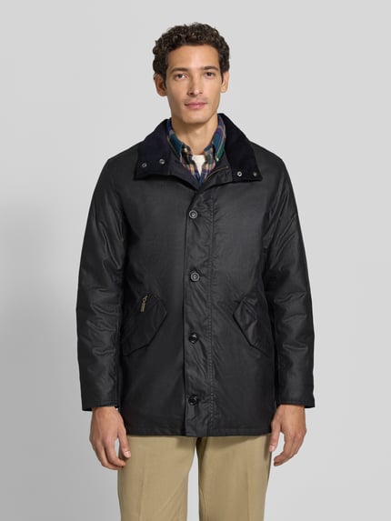 Männermodel trägt Regular Fit Parka aus reiner Baumwolle von Barbour in Schwarz mit glatter Textur, Ganzkörperansicht von vorne. Herren Parka von Barbour