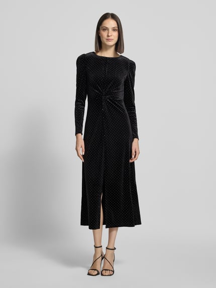 Frauenmodel trägt Cocktailkleid im Allover-Look Modell 'HELLA' von YAS, schwarzer Material-Mix, figurbetont, Gehschlitz, Ganzkörperansicht von vorne.
