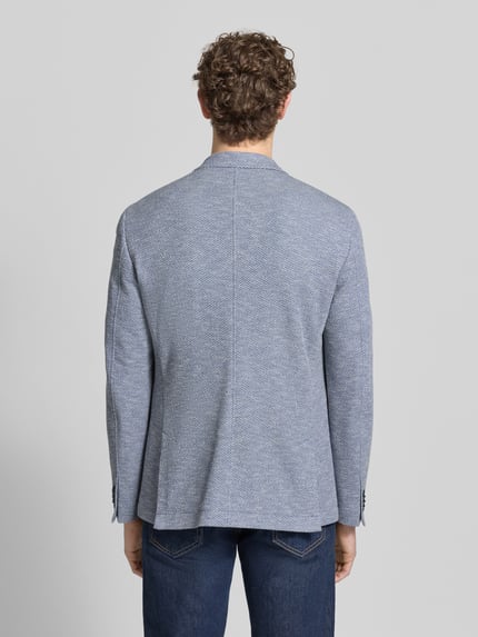 Männermodel trägt Slim Fit 2-Knopf-Sakko mit Reverskragen von bugatti aus Baumwoll-Mix mit Stretch-Anteil, Strukturmuster, Ganzkörperansicht Rückansicht.